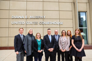 Ericksons, Loes, and School Representatives outside the District County Courthouse in Minnesota