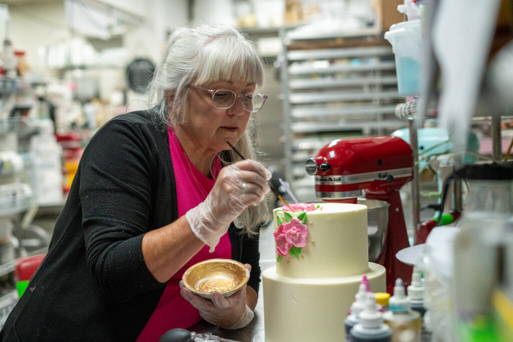 Cathy Miller paints details onto a custom cake.